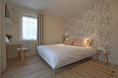 1 dormitorio con cama, escritorio y ventana en Le Bois aux Cerfs, en Bois-Jérôme-Saint-Ouen