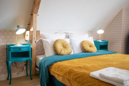 - une chambre avec un lit et 2 tables bleues dans l'établissement La Bellevue Bréville - B&B, à Bréville-sur-Mer