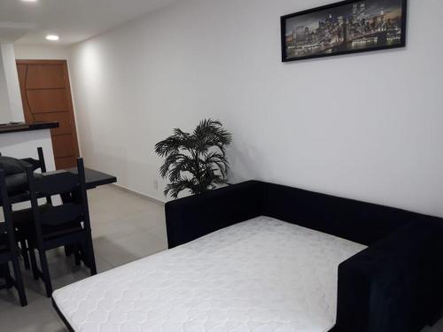 a bedroom with a bed and a table and a plant at Apto Le Bon Vivant Vista Mar in Arraial do Cabo