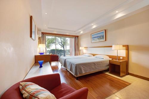 a hotel room with a bed and a couch at Boca do Rio - Apartamento T1 in Lagoa