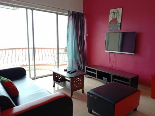 un salon avec un canapé et une télévision à écran plat dans l'établissement JC Sunshine Bay Resort Apartment Port Dickson, à Port Dickson