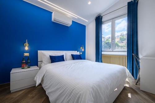 um quarto azul com uma cama branca e uma janela em VILLA IN BED em Quarto