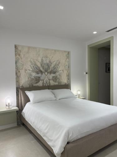 a bedroom with a large white bed with a floral headboard at Five stars Florence luxury apartments in Florence