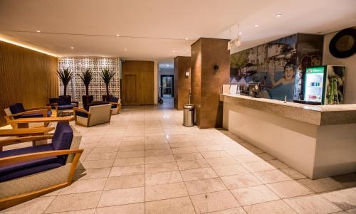 a lobby of a hotel with chairs and a counter at Hotel Morada do Sol in Caldas Novas