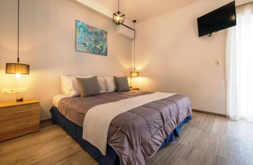 1 dormitorio con 1 cama y TV en la pared en Sophies Greek Gateway, en Kardamaina