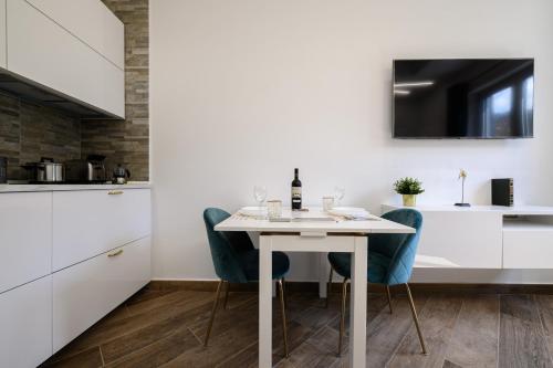 a kitchen and dining room with a white table and chairs at VILLA IN BED in Quarto
