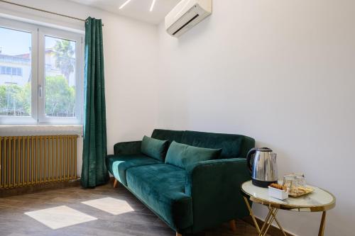 a living room with a green couch and a table at VILLA IN BED in Quarto