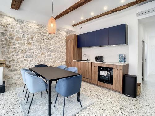 une salle à manger avec une table noire et des chaises bleues dans l'établissement 2 bedroom Majestic, 1 min to the Croisette 357, à Cannes