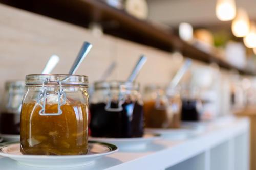 a row of jars of honey on a counter at Rathener Hof by STEIGER Hotels in Kurort Rathen