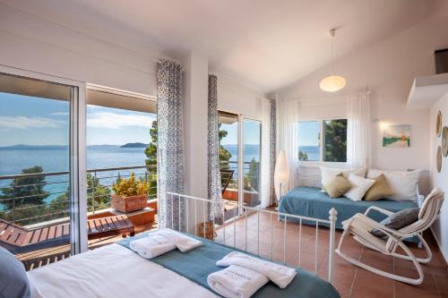 een slaapkamer met 2 bedden en uitzicht op de oceaan bij Alterra Vita Homes By the Sea in Neos Marmaras