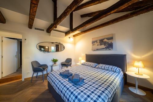 a bedroom with a bed and two chairs and a mirror at Centrale appartamento per 4 persone in Venice