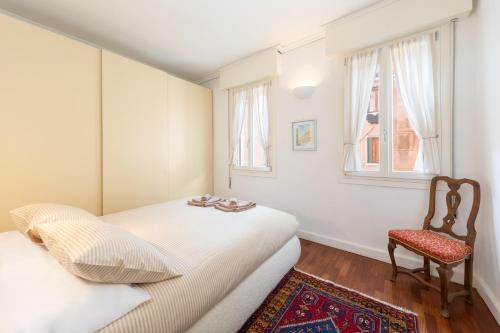 - une petite chambre avec 2 lits et une chaise dans l'établissement COLOMBINA HOME Venice with canal view, à Venise