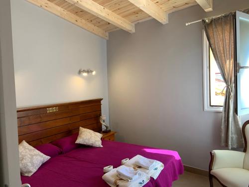 een slaapkamer met een paars bed met een stoel en een raam bij Agradable casa con chimenea y patio totalmente privado in Barahona