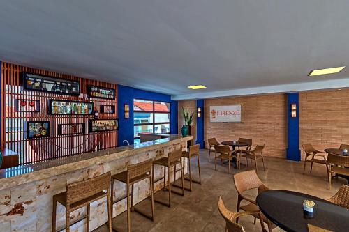 a bar with tables and chairs in a restaurant at Hotel Firenze in Serra Negra