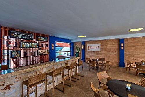 un bar con tavoli e sedie in un ristorante di Hotel Firenze a Serra Negra