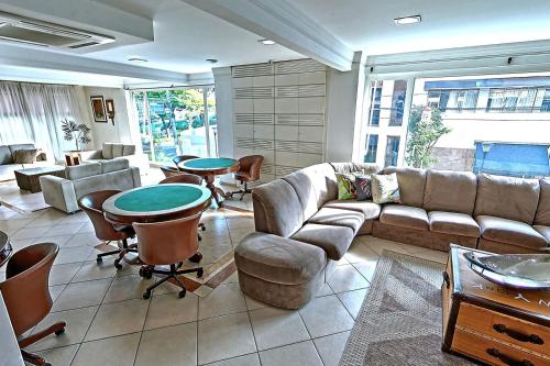 a living room with a couch and a table and chairs at Hotel Firenze in Serra Negra