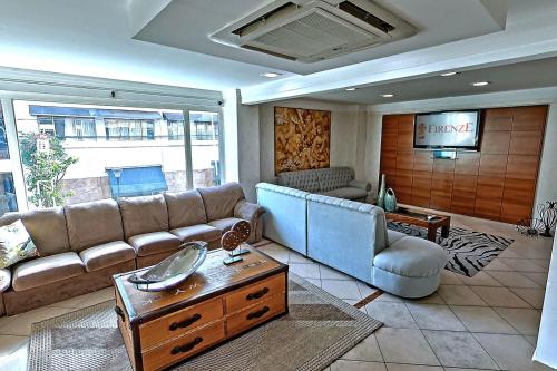 a living room with a couch and a tv at Hotel Firenze in Serra Negra
