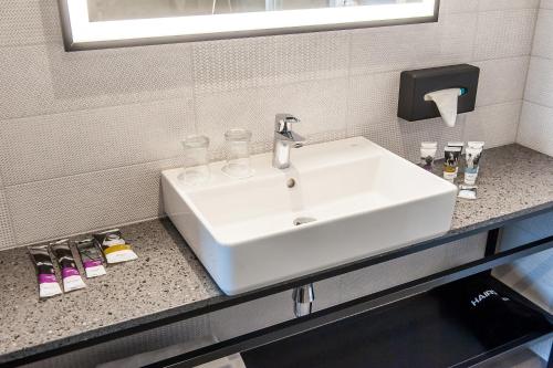 a white sink in a bathroom with a mirror at Mercure Bialystok in Białystok