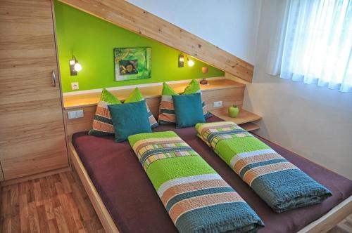 two beds in a room with a green wall at Feldhof Apartment Apfeloase in Caines