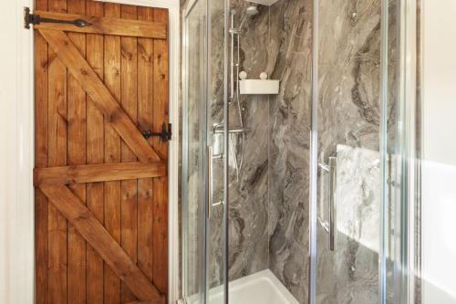 a bathroom with a shower with a wooden door at Wingate Farm, Countisbury in Countisbury