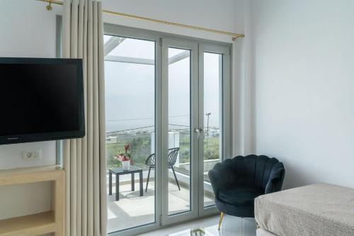 a living room with a sliding glass door to a balcony at Golden Star in Fira