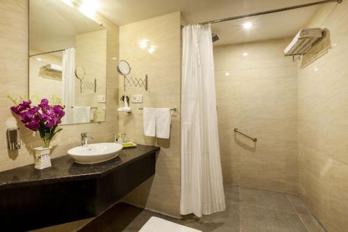 a bathroom with a sink and a shower at Presidency Landmark in Daman