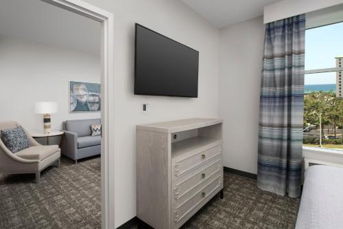 a living room with a television and a chair at Homewood Suites By Hilton Destin in Destin