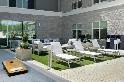 a group of white chairs and tables on a patio at Homewood Suites By Hilton Destin in Destin