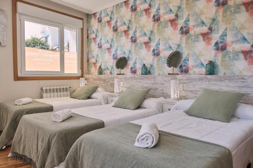 Zimmer mit 3 Betten und Wandgemälde in der Unterkunft Pensión A Solaina 2 in O Pino 