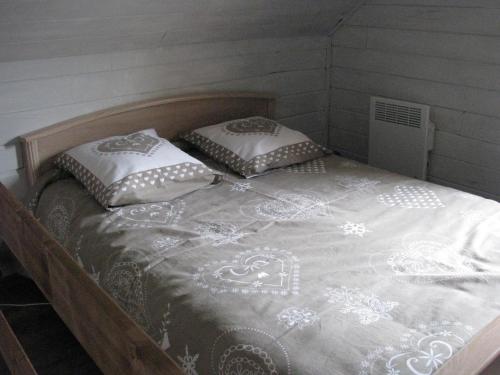 a bed with two pillows on it in a room at Apartment Chalet Bourg d'Oisans in Le Bourg-dʼOisans