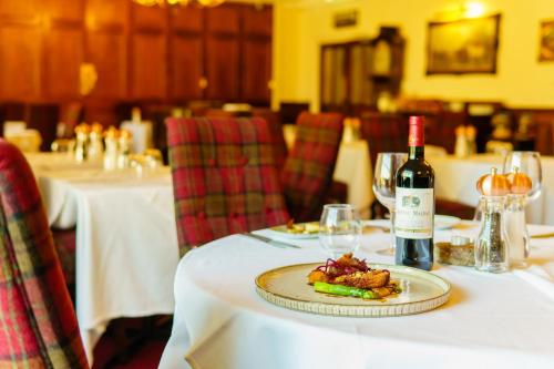 a table with a plate of food and a bottle of wine at Two Bridges Hotel in Two Bridges