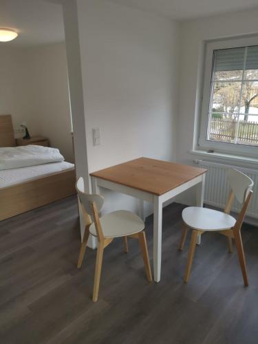 Zimmer mit einem Tisch, 2 Stühlen und einem Bett in der Unterkunft Ferienhaus KaTi Whg1 in Knüllwald
