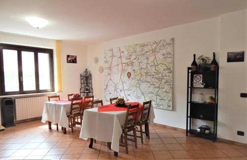 un comedor con 2 mesas y un mapa en la pared en Amo' le Langhe, en Narzole