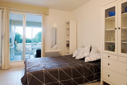 a bedroom with a bed and a sliding glass door at L'Aigrette - Front de mer-Accès direct plage in Leucate