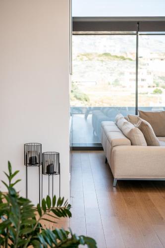 a living room with a couch and a large window at Seametry Luxury Living Penthouse in Souda