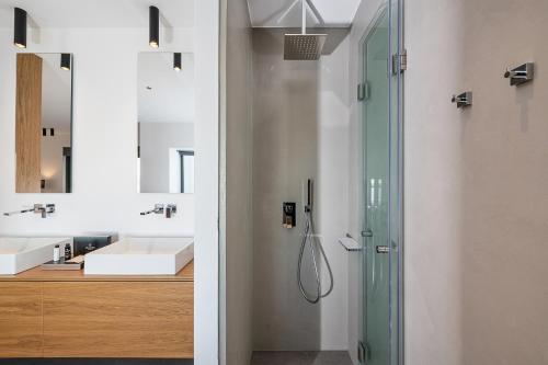 a bathroom with a glass shower and a sink at Seametry Luxury Living Penthouse in Souda