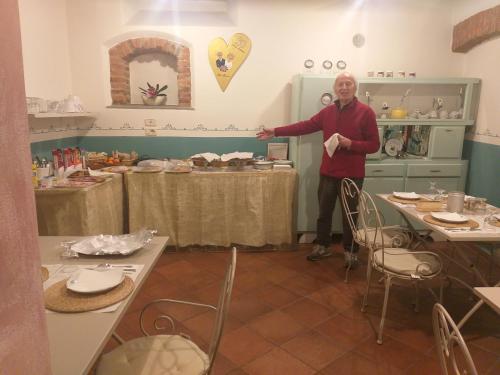a man is standing in a room with tables at B&B LA CHIMERA in Arezzo