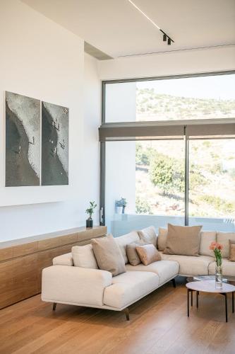 a living room with a white couch and a large window at Seametry Luxury Living Penthouse in Souda