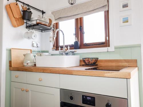 a kitchen counter with a sink and a window at Badgers Rest in Tintagel