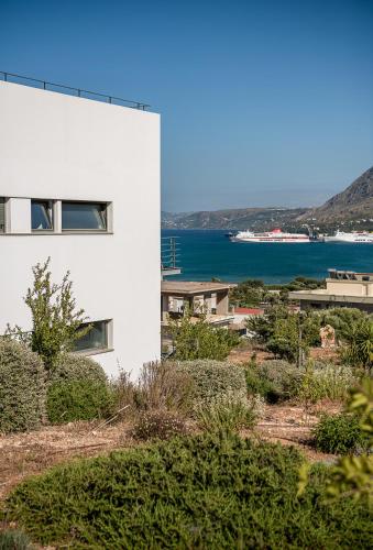 a white building with the ocean in the background at Seametry Luxury Living Penthouse in Souda