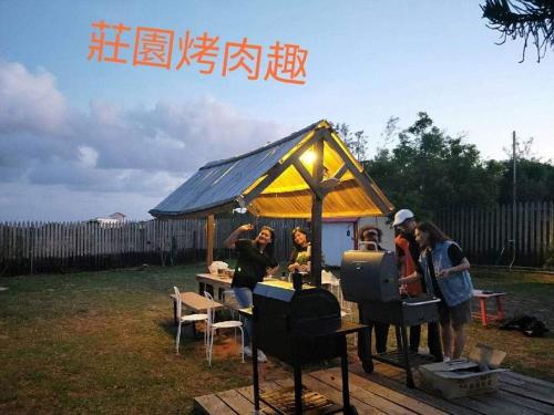 un groupe de personnes debout dans une tente dans l'établissement 墾丁勿忘我城堡莊園, à Hengchun Old Town