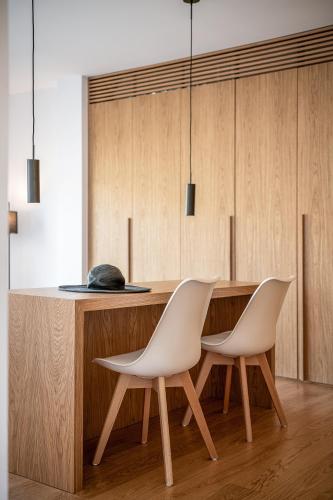 two white chairs sitting next to a wooden table at Seametry Luxury Living Penthouse in Souda