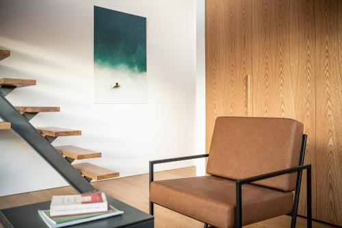 a chair in a living room with a table and a staircase at Seametry Luxury Living Penthouse in Souda