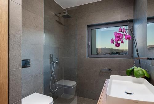 a bathroom with a sink and a toilet and a window at Seametry Luxury Living Penthouse in Souda