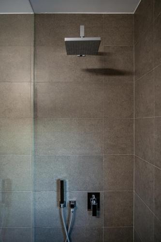 a tiled bathroom with a shower with a light at Seametry Luxury Living Penthouse in Souda