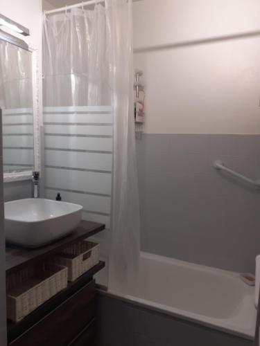 une salle de bain blanche avec un lavabo et une douche dans l'établissement T2 Bord de mer avec jardin et piscine, à Saint-Aygulf