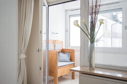 uma sala de estar com uma cadeira e um vaso com flores em Apartment - Feldstrasse 30-O Winterberg em Winterberg