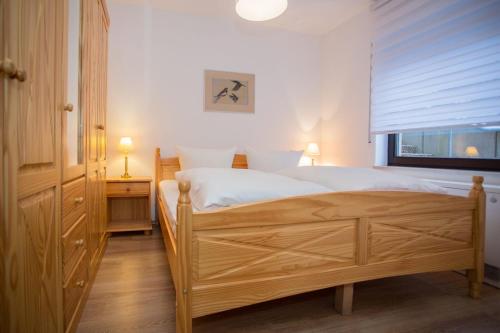 1 dormitorio con cama de madera y ventana en Apartment - Am Bergelchen 66-B Winterberg-Niedersfeld 'Mountainside', en Winterberg
