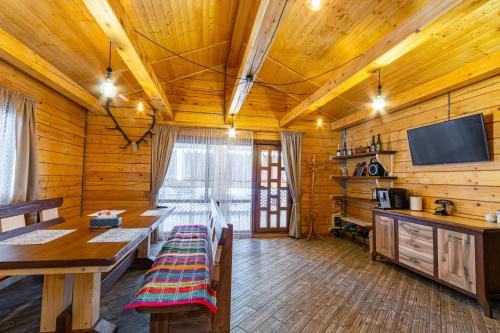 a dining room with a table and a tv in a cabin at Nikol in Turitsa