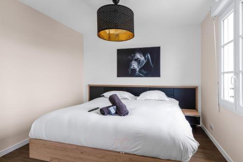 een slaapkamer met een wit bed met een zwart hoofdeinde bij *DISNEYLAND-SERRIS* 4 pers Cosy apartment in Serris